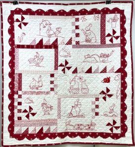 red and white quilt with bunnies